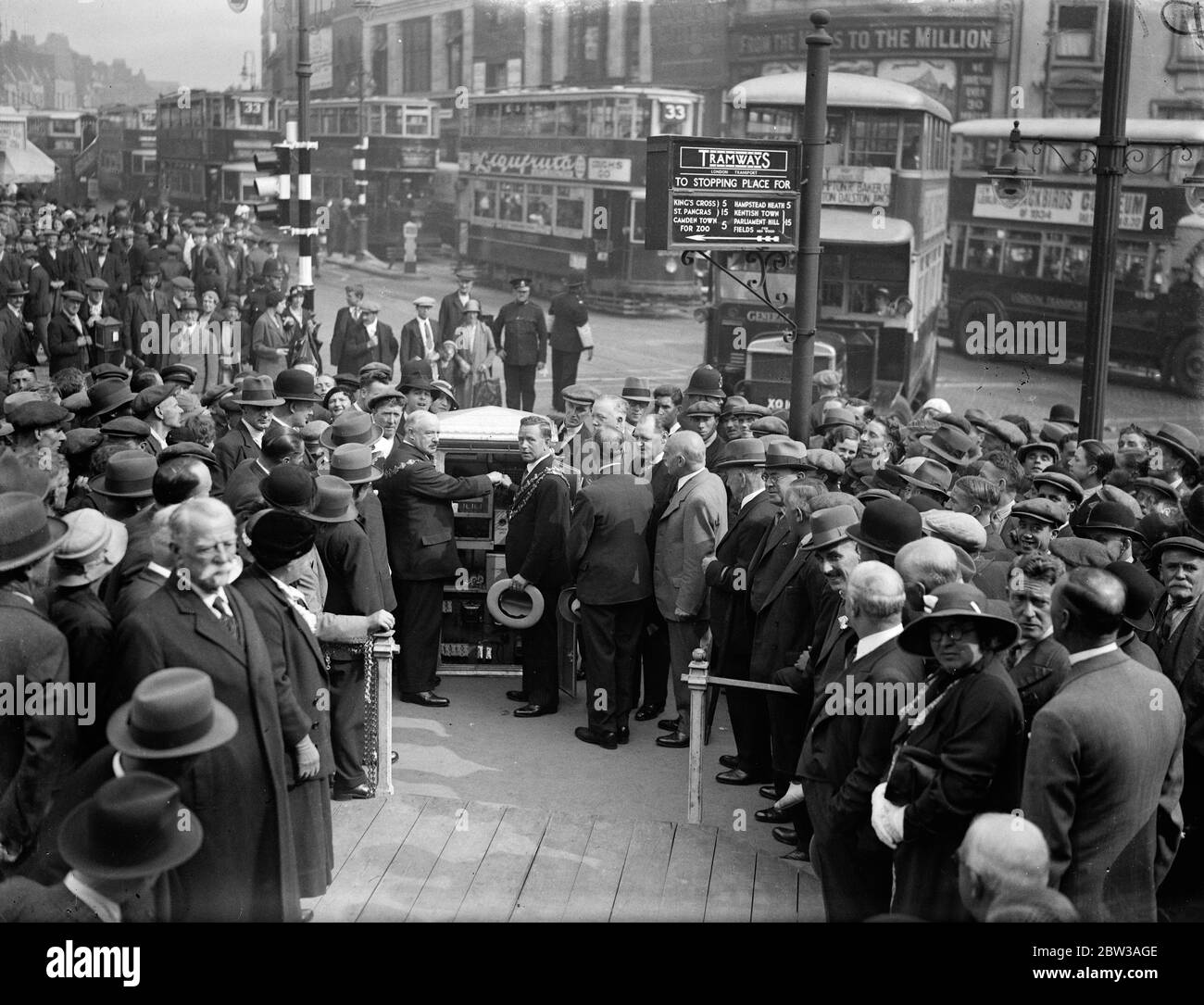 Due Mayor impostano nuovi segnali stradali per il Nord di Londra in funzione . I nuovi segnali di traffico all' Angel Junction , N , sono stati attivati dai Sindaci di Finsbury e Islington . I due Sindaci che iniziano i segnali seguiti da una folla . Tram e autobus in background . A sinistra è il sindaco di Finsbury , Consigliere G Tripp , a destra è il sindaco di Islington , Alderman B Holden . 6 settembre 1934 Foto Stock