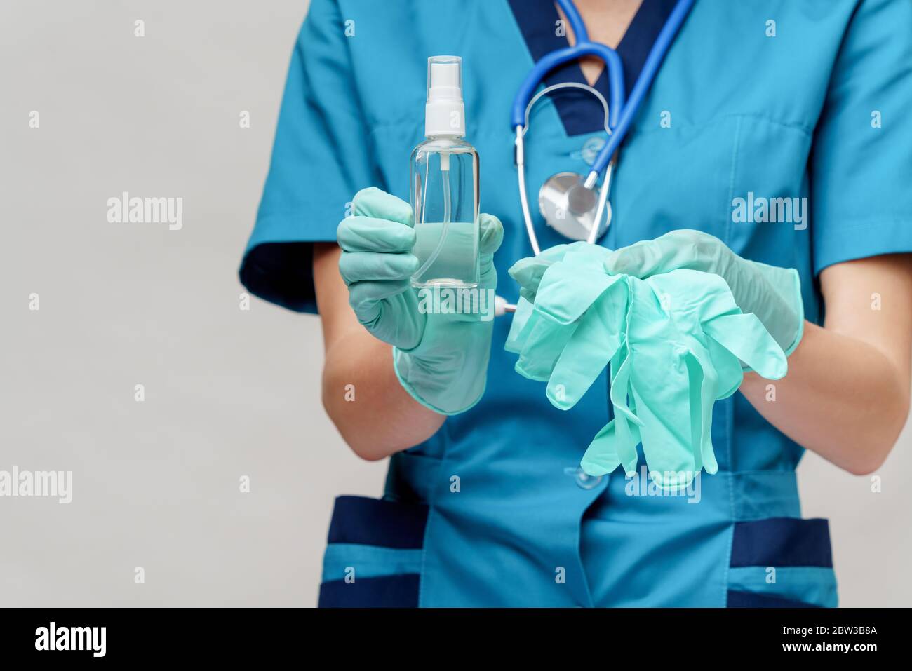 medico medico infermiere che indossa la maschera protettiva - contenente il flacone di spray o gel igienizzante Foto Stock