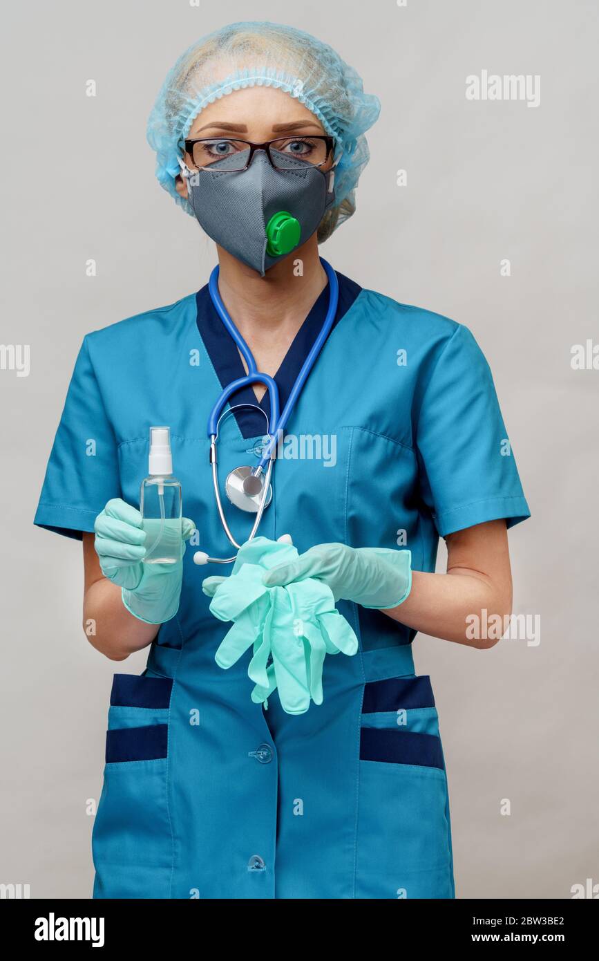 medico medico infermiere che indossa la maschera protettiva - contenente il flacone di spray o gel igienizzante Foto Stock