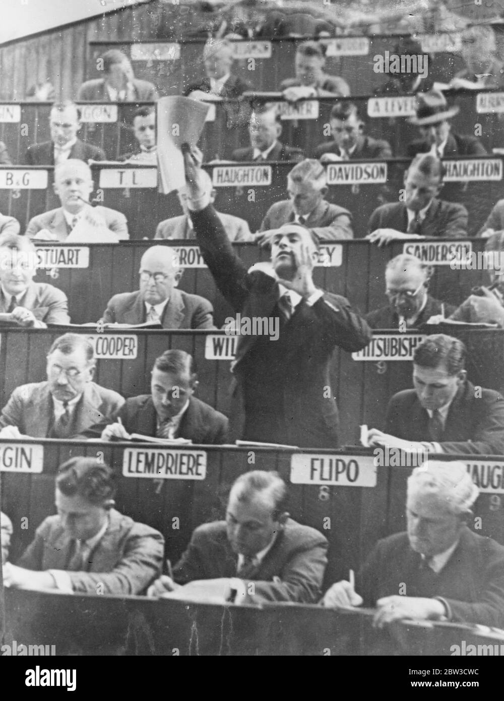 Gli acquirenti hanno prenotato posti a sedere alle vendite australiane di lana . Un compratore salta ai suoi piedi per fare un'offerta . 3 novembre 1935 Foto Stock