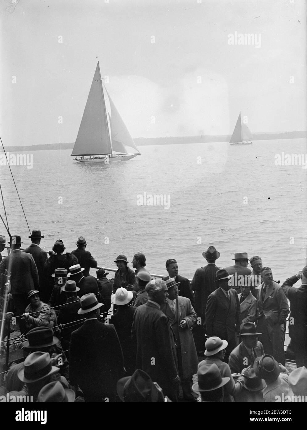 Vista del grande stand della corsa 'Endeavour' durante la settimana di Cowes. I passeggeri del concorso "Greeting s" di Brema hanno una vista ravvicinata della barca del signor T o M Sopwith Endeavore mentre corre a Cowes Roads durante la regata del Royal Thames Yacht Club. 1 agosto 1935 Foto Stock