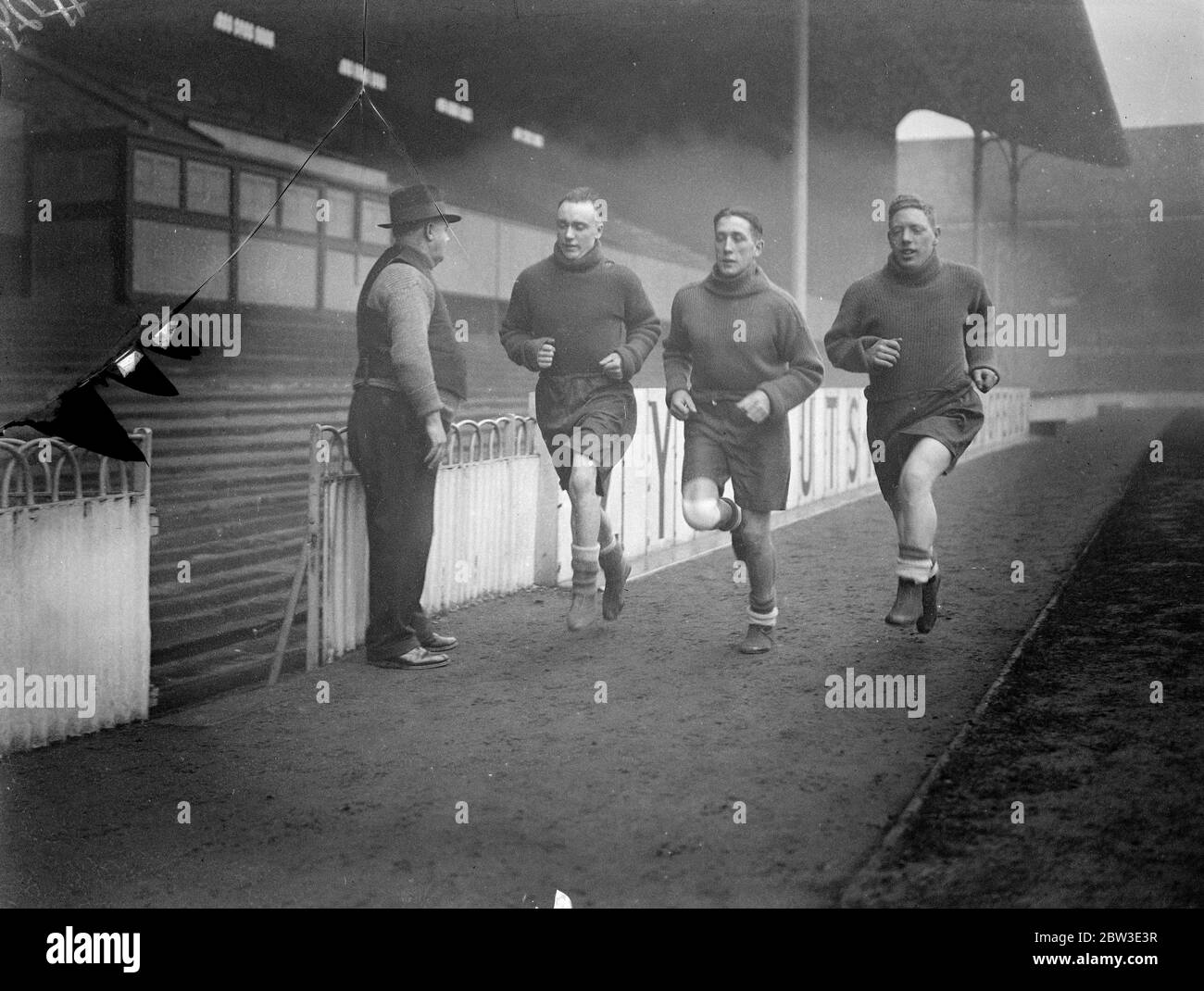 Gli invalidi di Tottenham ritornano in allenamento , George Hunt , Arthur Rowe e Willie Hall che si sprinting intorno alla White Hart Lane , guardato da George Hardy , allenatore dei club . 24 gennaio 1935 Foto Stock Gli invalidi di Tottenham ritornano in allenamento , George Hunt , Arthur Rowe e Willie Hall che si sprinting intorno alla White Hart Lane , guardato da George Hardy , allenatore dei club . 24 gennaio 1935 Foto Stock