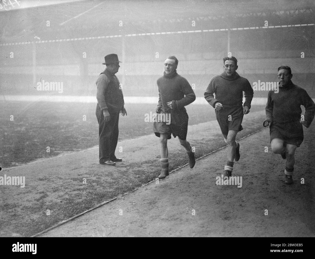 Gli invalidi di Tottenham ritornano in allenamento , George Hunt , Arthur Rowe e Willie Hall che si sprinting intorno alla White Hart Lane , guardato da George Hardy , allenatore dei club . 24 gennaio 1935 Foto Stock Gli invalidi di Tottenham ritornano in allenamento , George Hunt , Arthur Rowe e Willie Hall che si sprinting intorno alla White Hart Lane , guardato da George Hardy , allenatore dei club . 24 gennaio 1935 Foto Stock