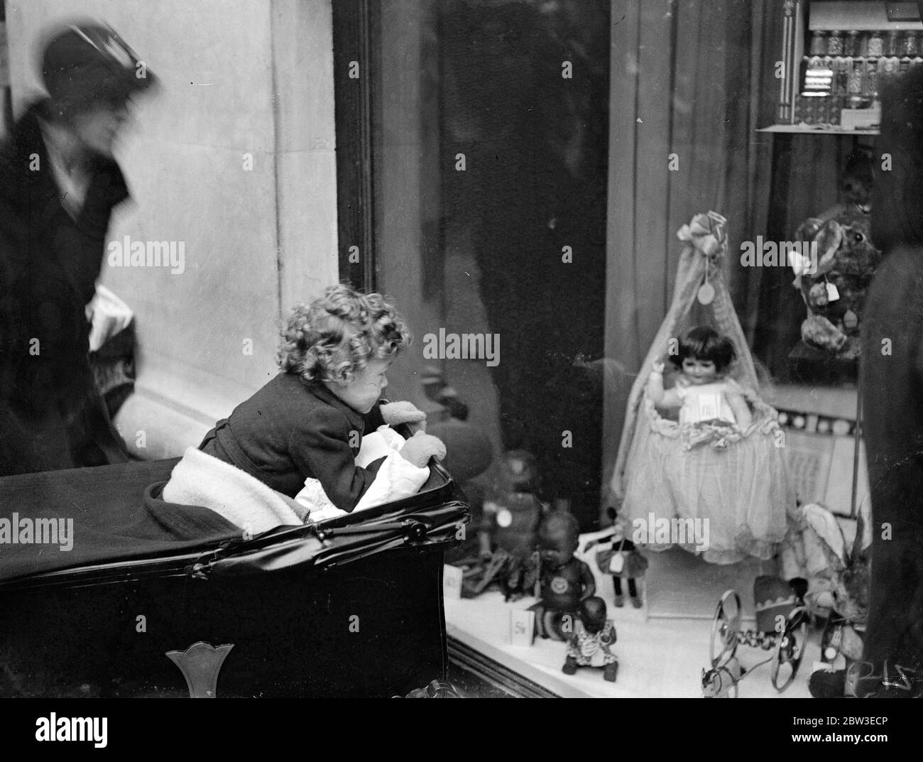 Non ancora a portata di mano . Bambino che cerca di ottenere un maggiore controllo sulle novità è una finestra di Oxford Street . 4 dicembre 1934 Foto Stock