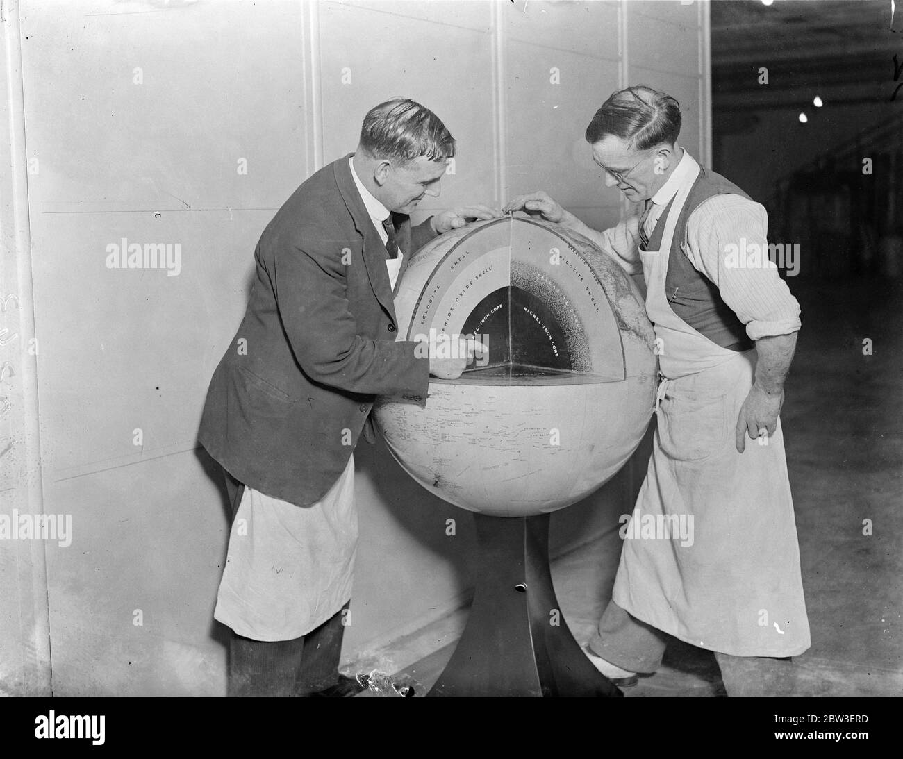 Lavoratori del nuovo Museo Geologico di Kensington con un globo del mondo , che viene tagliato ed espone le diverse composizioni al centro della terra . 15 gennaio 1935 Foto Stock