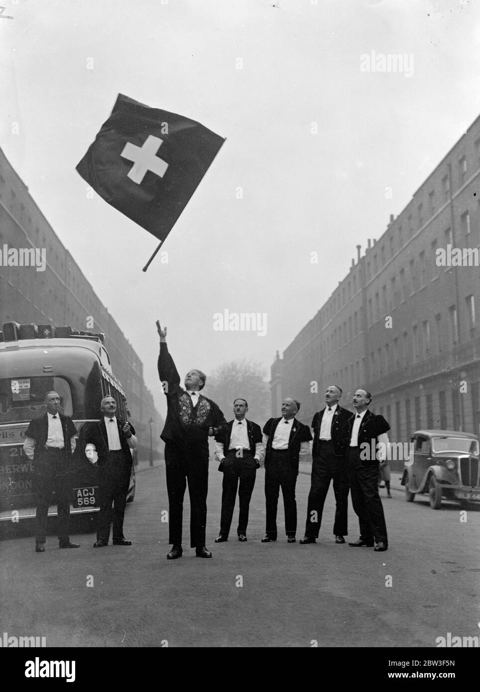 Il campione svizzero lanciatore di bandiere a Londra . Franz Hug , campionessa di bandiera svizzera , ha dato una dimostrazione subito dopo essere arrivata a Londra con un gruppo di 16 yodelers svizzeri che domani canteranno all' Albert Hall ( sabato ) . La festa è in costume nazionale . Spettacoli fotografici , Franz Hug che dà una dimostrazione . 6 marzo 1936 Foto Stock