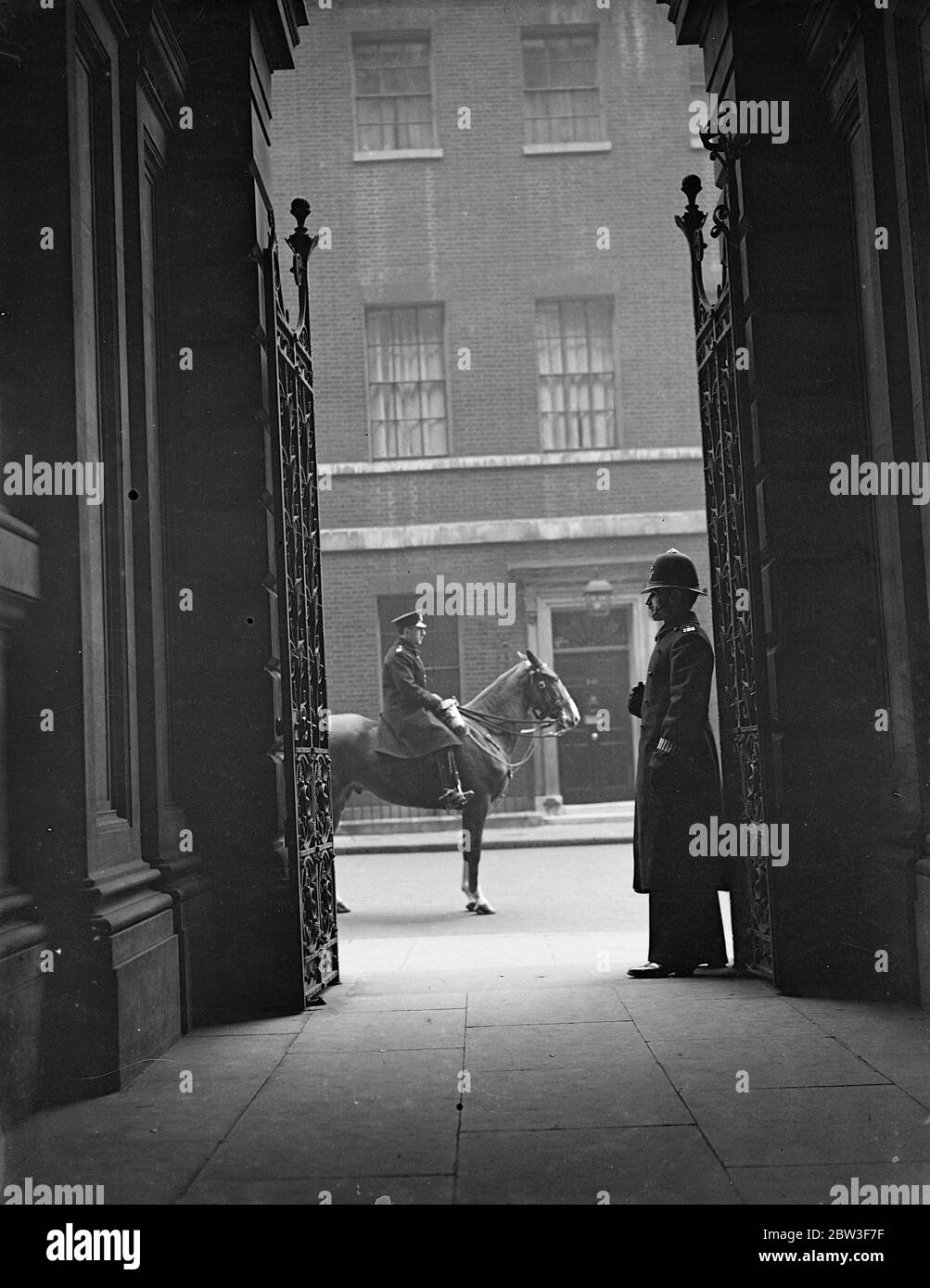 Protezione montata in Downing Street . La polizia a piedi e montata è in guardia a Downing Street, dove si radunano grandi folle per assistere ai movimenti dei ministri e degli statisti stranieri . Foto spettacoli , montato e guardia di polizia a piedi in Downing Street . 13 marzo 1936 Foto Stock