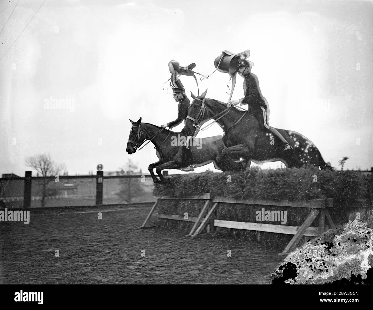 Prova di cavalleria per il torneo reale . Saddling i loro montaggi sopra i salti mozzafiato e di effettuare le imprese più difficili con l'equitazione superbe , i troopers della scuola di Equitazione a Weedon , Northamptonshire , stanno risanando per il torneo reale , che apre ad Olympia il mese prossimo . Gli uomini che partecipano sono raccolti da unità di cavalleria del centro commerciale dell'esercito britannico. Spettacoli fotografici , selle tenute in alto in aria , i troupiers della Scuola di Equitazione prendono un salto difficile . 14 aprile 1936 Foto Stock