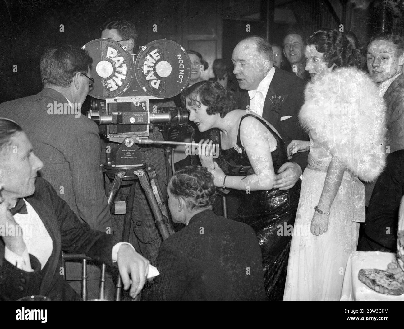 Luci di spicco dell'intrattenimento britannico brillano alla palla ' Lights out '. Centinaia di persone tra le più famose del mondo dell'intrattenimento britannico hanno partecipato alla palla annuale di Lawrence Wright ' Lights out ' presso la Royal Opera House , Covent Garden . Foto spettacoli , Miss Betty Warren , moglie di Lawrence Wright , facendo un film della palla guardato da suo marito e Miss Costanza Carpenter , l'attrice cinematografica americana . 5 marzo 1936 Foto Stock