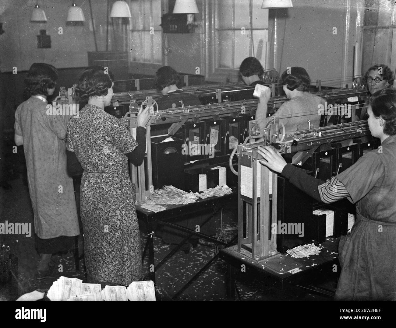 Smistamento 2 , 000 , 000 ordini postali a 15 , 000 un'ora ingegnose macchine di ufficio postale trattare con ordini di calcio . Smistamento e raccolta di ordini postali nel loro ordine seriale al tasso di 15 , 000 un'ora , cinque volte più veloce delle mani umane può farlo una dozzina di macchine ingegnose sono state installate al reparto di ordine di denaro del GPO in Cornwallks Road , Holloway , per gestire gli ordini di . Un numero enorme di ordini postali viene gestito principalmente dalle piscine di calcio . Uno dei più grandi concearns inviare in 2 , 000 , 000 un giorno al valore di tatl di Â£ 260 , 000 . Le macchine selezionano t Foto Stock