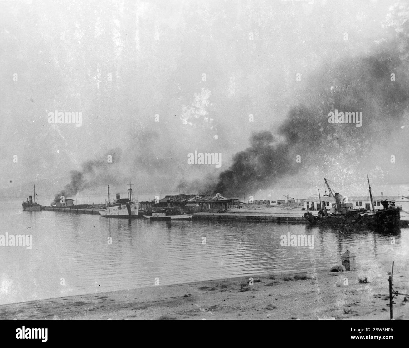 Nave da guerra del governo Bombard Algeciras nella guerra civile spagnola . Con l'incrociatore ribelle dato nelle vicinanze, la nave da guerra governativa Jaime i bonbardment, la città di Algeciras, situata a cinque miglia ad ovest di Gibilterra. Non prima che i banchine fossero stati danneggiati in modo esteso e la città fu Jaime i scacciata da aerei ribelli . Il consolato britannico della città fu gravemente danneggiato e il Console e sua moglie ebbero scappatesi stretti . I residenti di Gibilterra guardavano il bombardamento dai tetti delle loro case . Foto : la banchina ardente di Algeciras dopo il bombardamento . 10 ago 1936 Foto Stock
