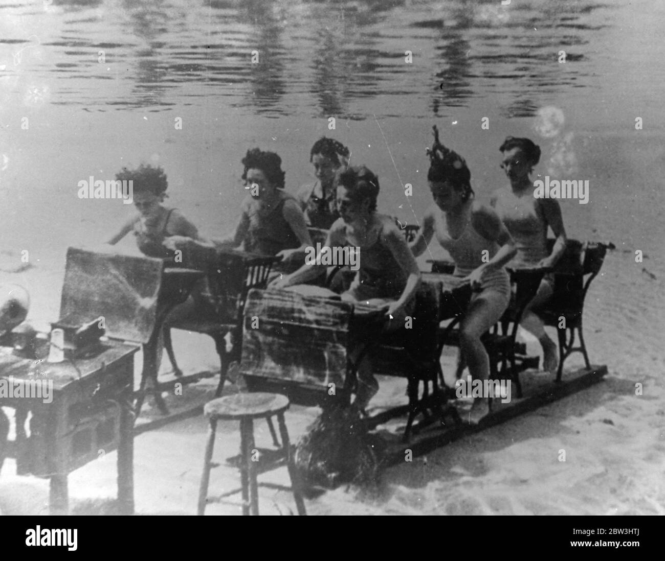 Queste immagini, alcune delle più insolite mai fatte, sono state scattate sotto il mare a Silver Springs, Florida, dove, tra i pesci molto colorati e i fronti ondulati delle piante sottomarine, la scuola più strana del mondo è stata stabilita sulle sabbie del fondale marino. Banchi di scuola , un tavolo di maestro e persino dunces sgabello alto sono stati presi sotto la superficie per la scuola , l'idea di un produttore che voleva un nuovo angolo per un fil che gli allievi, tutti i nuotatori esperti, anche eseguire una palestra per la ricreazione sotto le onde . Spettacoli fotografici, la scuola subacquea in sessione sul fondale a Silver Springs, Flor Foto Stock