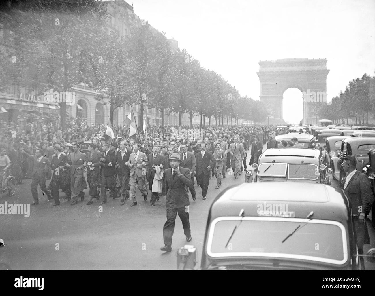6 , 000 polizia e guardie club loro strada attraverso Parigi mobs , le donne picchiate . Quattromila poliziotti che usavano pugni e batoni , e 2 , 000 guardie mobili , che tormentavano le loro carpini , si accamparono attraverso una folla riunita alla Tomba del Milite Ignoto all' Arc de Triumph di Parigi . Gli uomini che si scontravano con la polizia sono stati picchiati a terra e calpestati , e persino donne e bambini sono stati attaccati in carica . La folla cantava la ' marseillaise' quando la polizia fece il loro attacco. Mostre fotografiche , ranghi impacchettati di manifestanti che cantano e sventolano bandiere , marciando lungo gli Champs-Ã Foto Stock