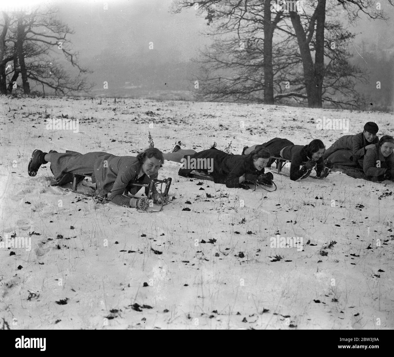 Lasciare le cose scivolare in Hertfordshire neve . Pronti per una slitta emozionante scendono su un pendio innevato nel distretto di Stevenage di Hertfordshire , dove le forti nevicate hanno dato un'insolita oppertunity agli amanti degli sport invernali . 21 dicembre 1935 Foto Stock