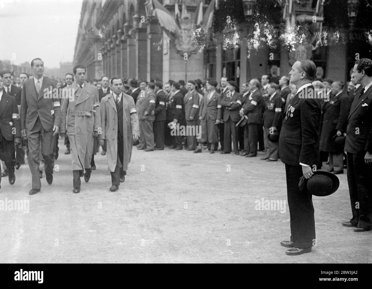 I membri della Croix de Feu marciano oltre il colonnello de la Rocque (in piedi all'attenzione con il cappello in mano a sinistra) in Place de Pyramides in rue de Rivoli . Maggio 1936 Foto Stock