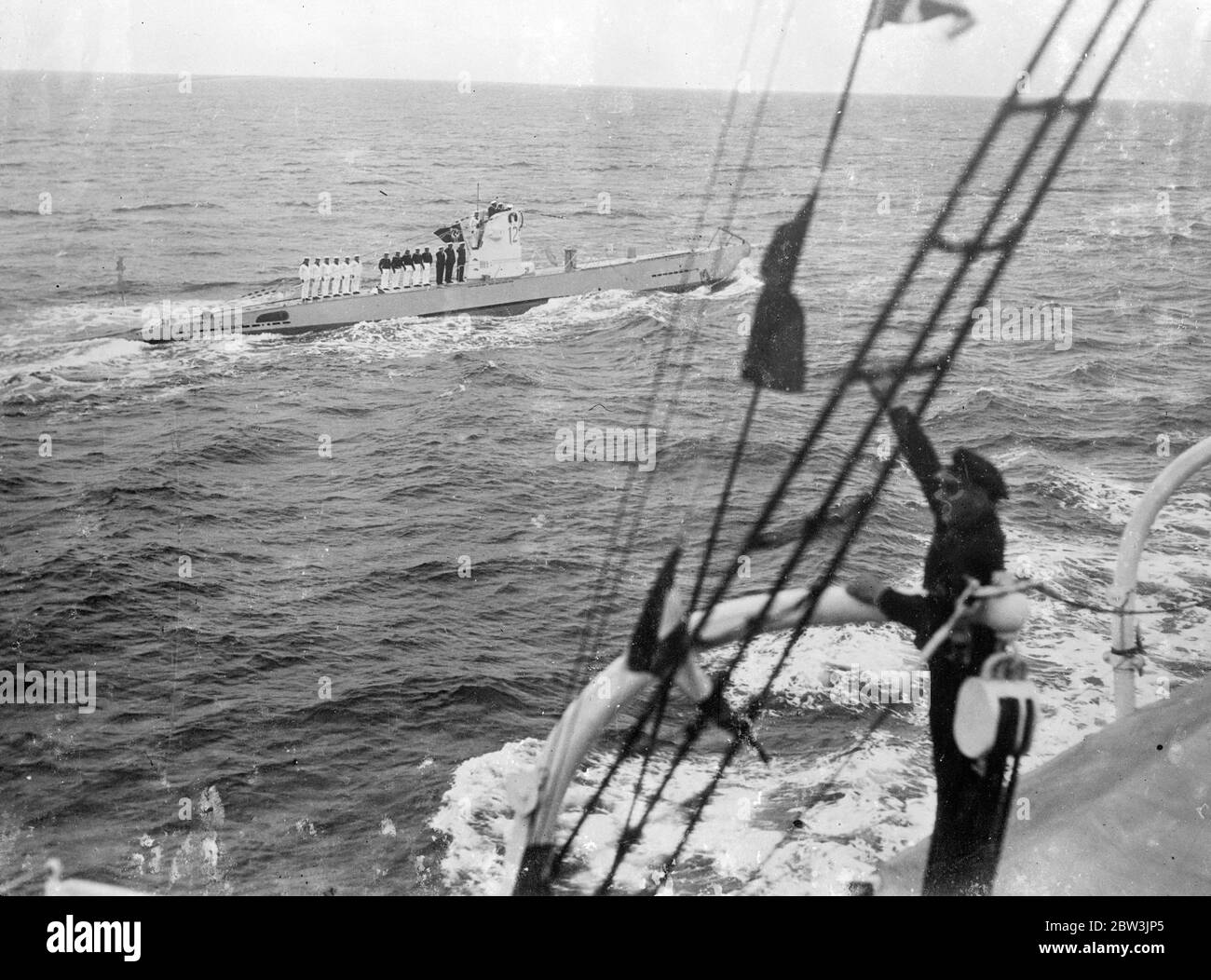 Nuovo sottomarino tedesco passa prima di Hitler in Greatest Fleet Display dalla guerra volare la bandiera nazista , sottomarini e navi da guerra tascabili della nuova flotta tedesca di High Seas partecipando alla più spettacolare mostra navale che si vede nelle acque tedesche dalla guerra , Passato in rassegna davanti al Cancelliere Hitler prima di uscire a vapore da Kiel per partecipare alle manovre combinate nel Baltico . Gli idrovolanti hanno preso parte alla mostra . Foto spettacoli : UN sottomarino tedesco che passa la corazzata dalla quale il Cancelliere Hitler ha preso il saluto . 31 maggio 1936 Foto Stock