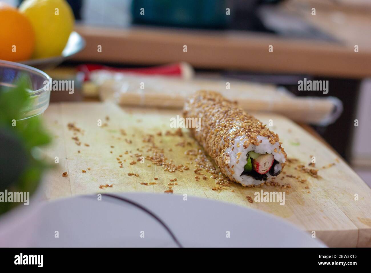 Sushi roll senza taglio stare su un tavolo rotolato in amici semi di sesamo Foto Stock