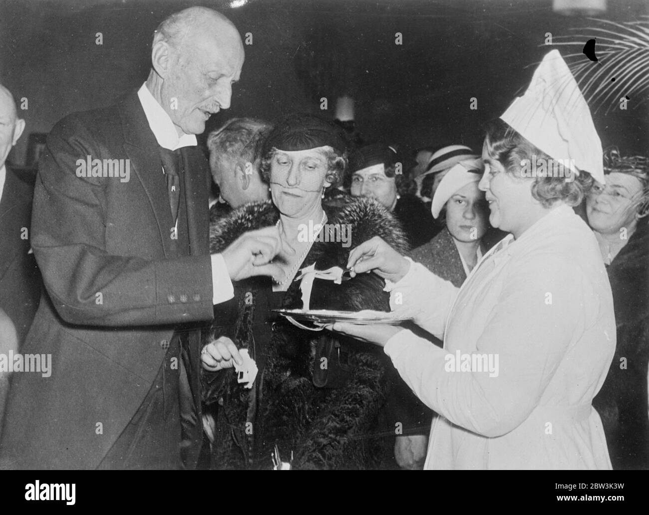 Il principe svedese Aand Princess assaggia il formaggio . Il principe Carl di Seden e la principessa Ingeberg hanno campionato il formaggio quando hanno visitato una Mostra dell'industria e dell'arte finlandesi organizzata a Stoccolma in connessione con la settimana finlandese . Spettacoli fotografici , il principe Carl e la principessa Ingeborg accettando il formaggio . 20 aprile 1936 Foto Stock