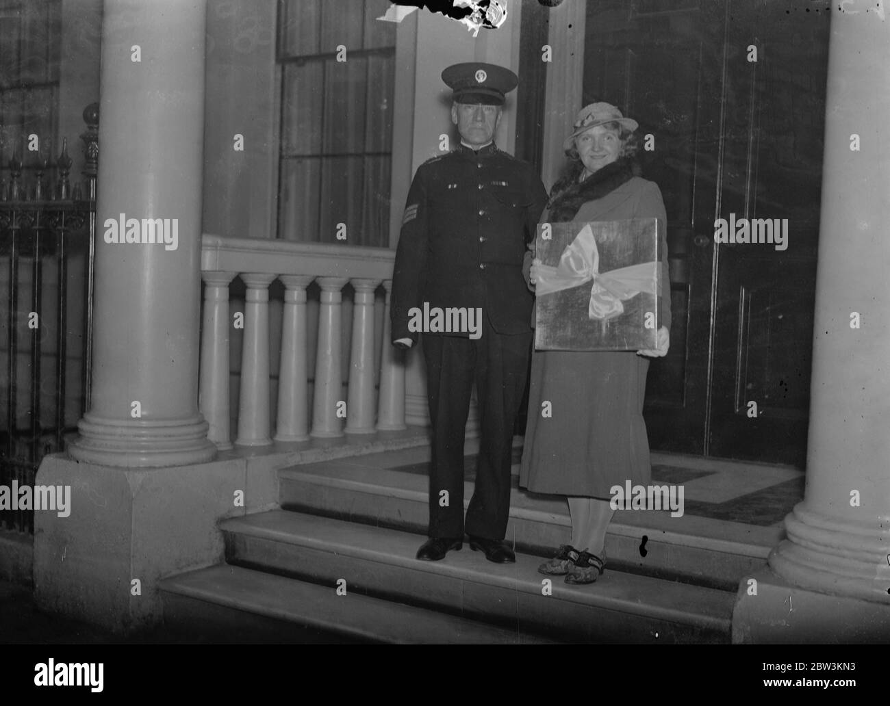 La ragazza cieca presenta la scialle al bambino di Duchessa di Kent . La sig.ra Edith Dadson visitò la n. 3 di Belgrave Square per presentare uno scialle fatto all'Istituto per ciechi di Bradford per il figlio del duca e della duchessa di Kent . 16 ottobre 1935 Foto Stock