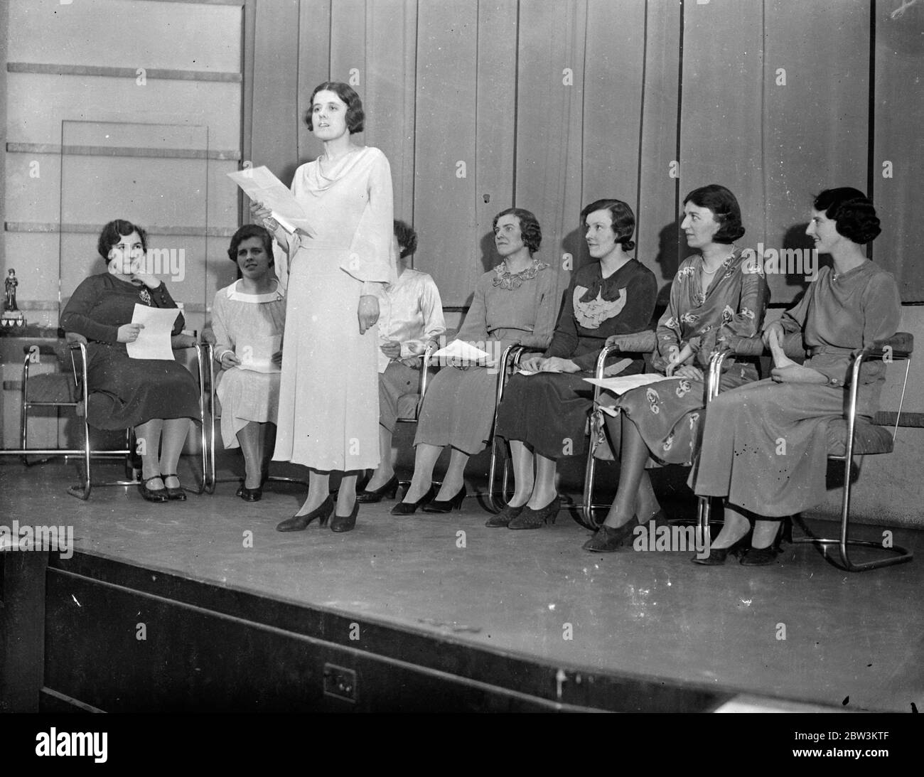 Le ragazze telefoniche londinesi recitano ' la pena d' amore' in finale al concorso di elocuzione . Le finali di un concorso di elettropuizione in cui hanno partecipato centinaia di ragazze telefoniche si sono svolte presso l' Ufficio postale di St Martin' s a le Grand . Due squadre , ciascuna delle quattro ragazze ha preso parte alla finale . Provenivano dallo scambio del Maryland , dai titolari del trofeo , e dalla Sezione statistica . I concorrenti dovevano recitare una poesia dal titolo' la pena D' amore'. Spettacoli fotografici , la signorina W CArwithan del team di Maryland Exchange reciting . Gli altri concorrenti sono seduti in background . 5 marzo 1936 Foto Stock