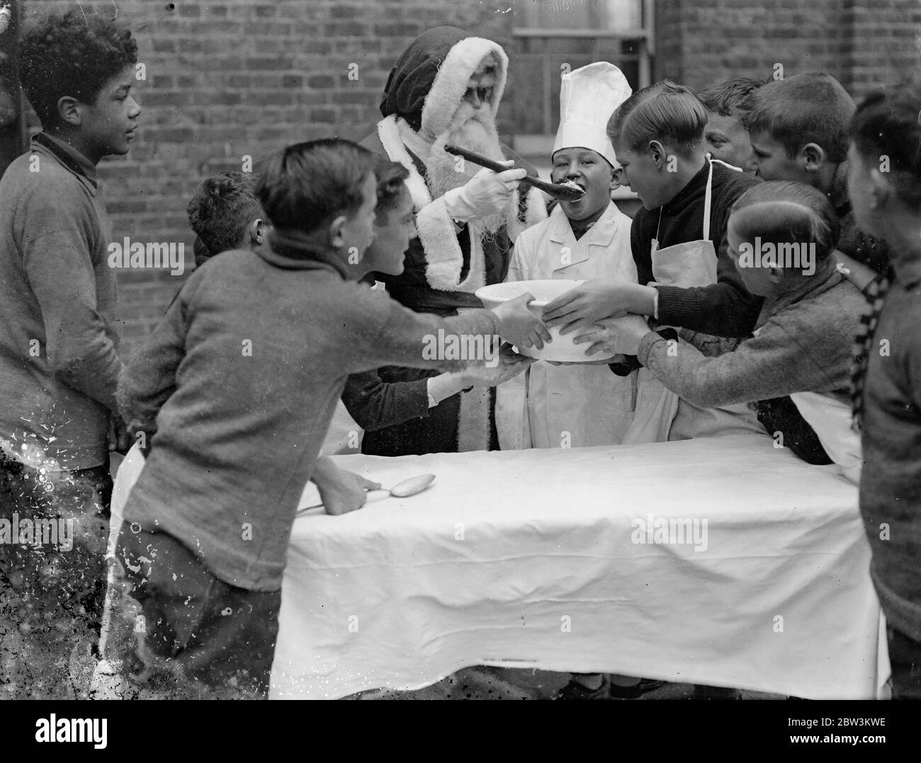 La prova del pudding ! . Le feste natalizie hanno avuto inizio presto alla Danziel del Dr Barnardo di Wooler Memorial Home , Kingston . Spettacoli fotografici , Padre Natale dà allo chef una tast della sua medicina . 30 novembre 1935 Foto Stock