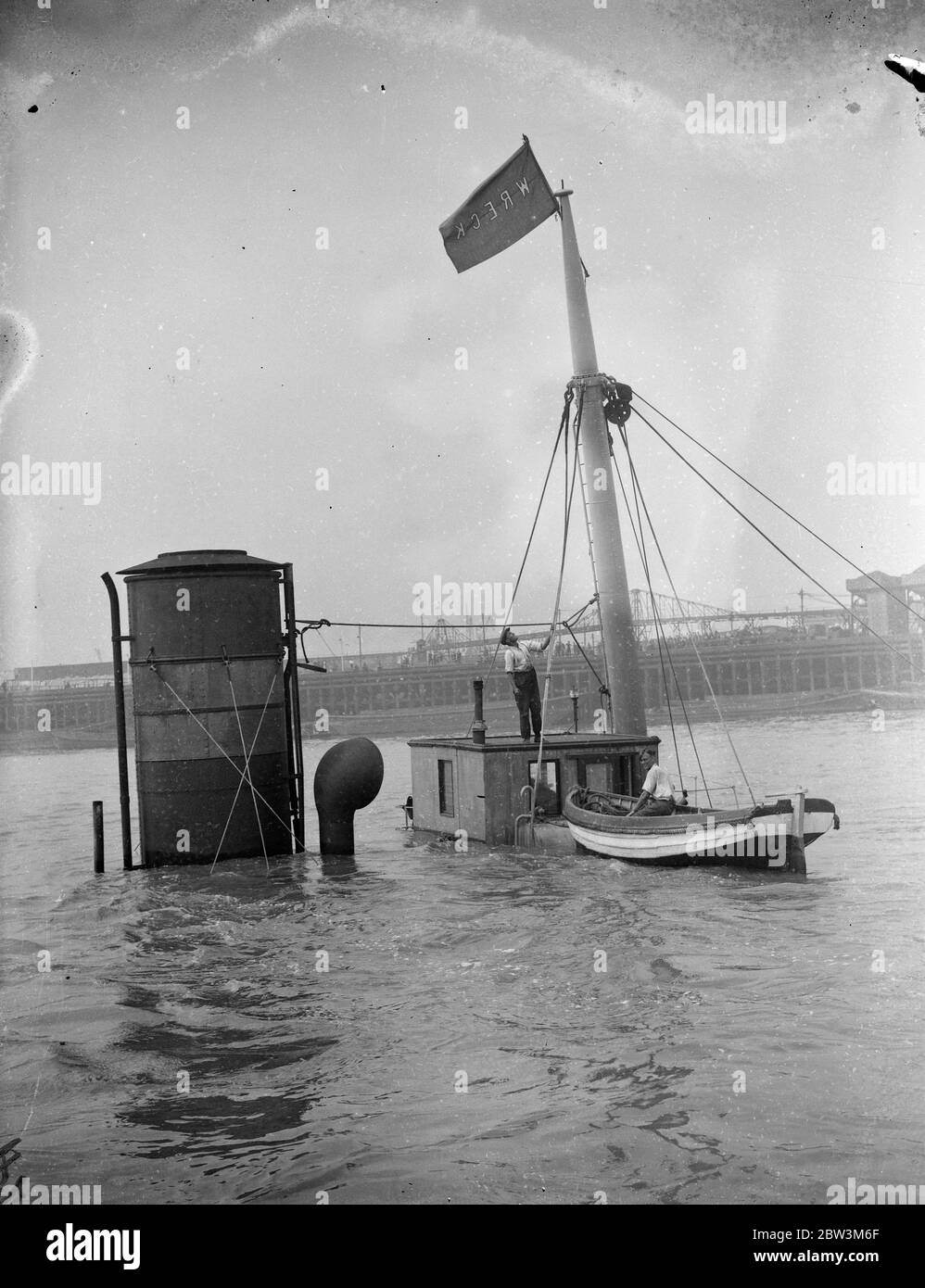Salvare gli uomini da P L A preparando il vaporetto relitto per l'innalzamento del Craggside nel Thame . Porto della London Authority , gli accendini dei relitti hanno iniziato le operazioni di salvataggio sulla nave Craggside (458 tonnellate) della Tyne Tecs che affondò a Gallions Reach , fuori dall' Albert Dock dopo una collisione con l'8S Ladura (9 , 032 tonnellate ) Appartenente alla British India Steam Navigation Company . Foto spettacoli , Salvage equipaggio della P L A relitto accendino preparando il relitto vaporiera per il sollevamento . 9 agosto 1935 Foto Stock