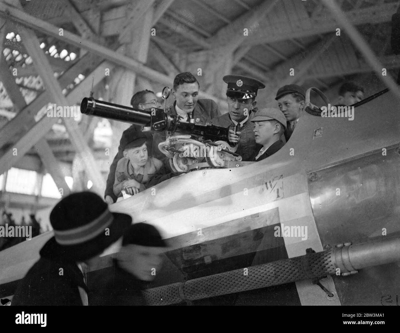 Gli studenti indagano sulle opere di un aereo da combattimento in Empire Air Day a Hendon . Grandi folle , tra cui molti bambini , hanno guardato l'esposizione Empire Air Day all'Hendon Aerodrome . L'11° Reggimento londinese (The Finsbury Frifles ) , che ora comprende le batterie degli aerei 171 e 170, ha collaborato con la Royal Air Force in mostra . Foto , studenti che sperimentano con l'anello di pistola Lewis in un Hawker Demon Fighter . 23 maggio 1936 Foto Stock