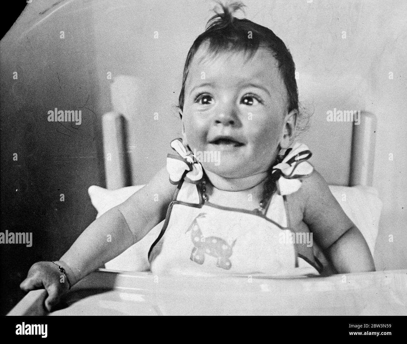 Enelie , uno dei famosi Dionne Quintuplets di Callendier , Ontario , sembra essere entusiasta all'estasi da una fata che si dispiega da un membro del personale del vivaio . 28 luglio 1935 Foto Stock