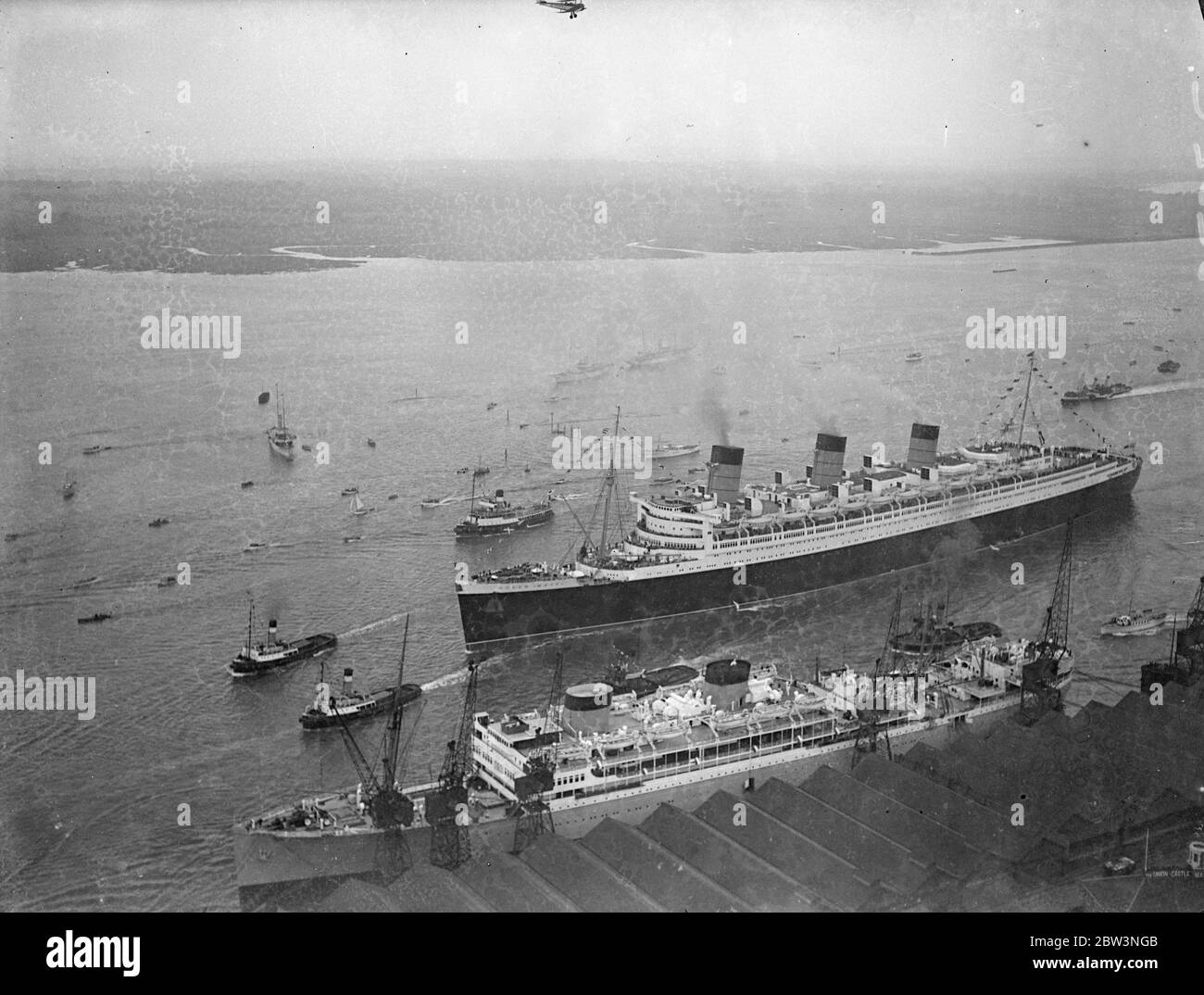 La ' RMS Queen Mary' salpa da Southampton in un viaggio da nubile. Allietato da un quarto di milione di persone che riempiono ogni pollice disponibile dei banchine . La Regina Mary, 80 anni, 000 e' orgogliosa della British Merchant Navy, salpò da Southampton in un suo primo viaggio in America. Era ' vestita su tutti ' con bandiere e centinaia di barche impavidite intorno a lei mentre si allontanava . Spettacoli fotografici , una vista aerea della 'RMS Queen Mary', lasciando i bacini di Southampton . 27 maggio 1936 Foto Stock
