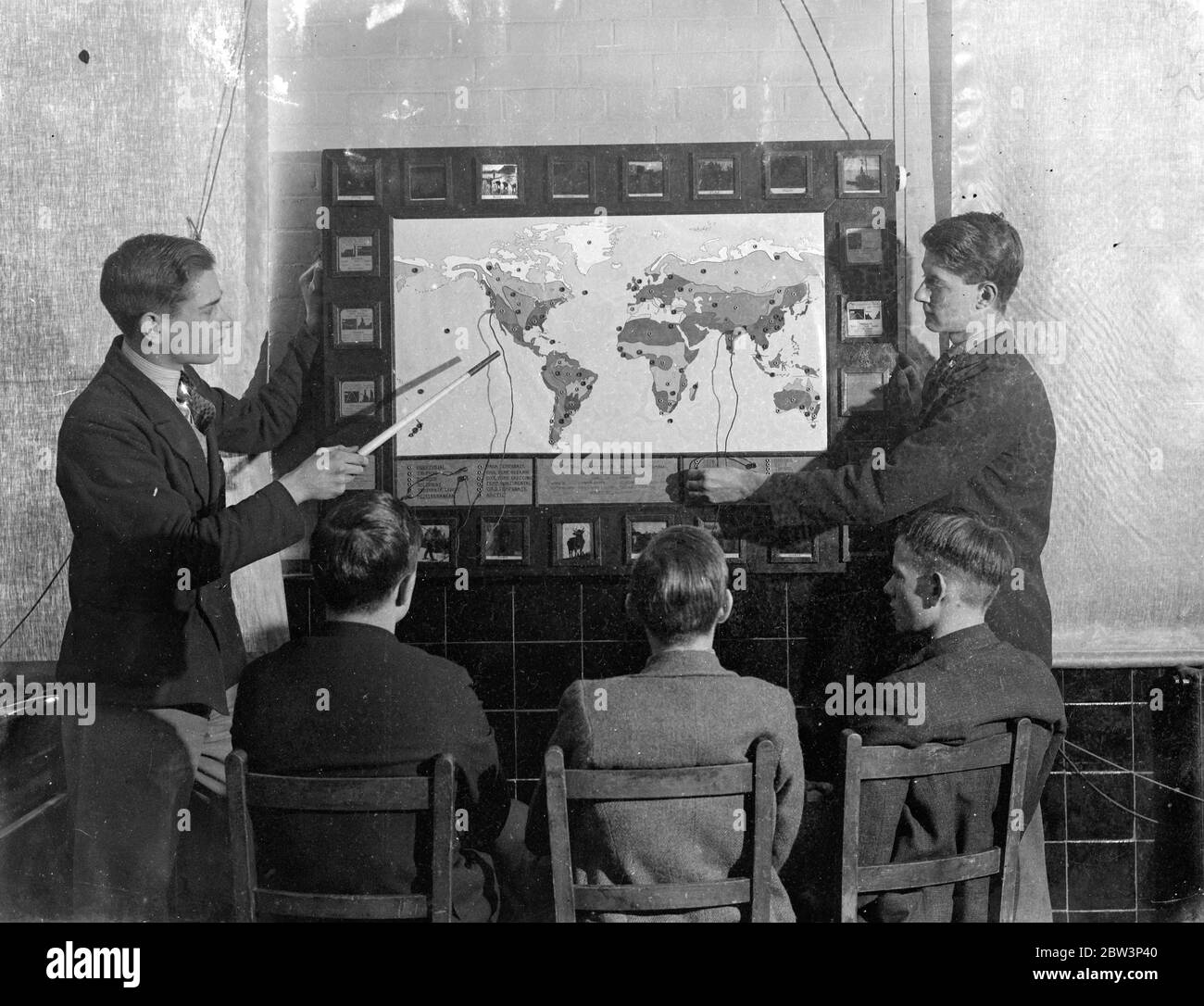 Il plug in' per i ragazzi di Londra, la mappa elettronica fatta in casa, li rende imparare e come . Gli studenti della Brockley Central School , Londra ora ' plug in ' per le lezioni di geografia . Il signor W T Harrison , maestro di geografia della scuola assistito dai maestri d' arte e di carpenteria e dai ragazzi della sesta forma , ha costruito una carta elettrica . Quando un ragazzo viene posto una domanda su qualsiasi parte del mondo , risponde inserendo una spina in una delle cento prese , una luce risplende dietro una slitta di vetro segnata dalla temperatura , dalle precipitazioni e dai principali prodotti della regione . Se il ragazzo usa la presa sbagliata , t Foto Stock