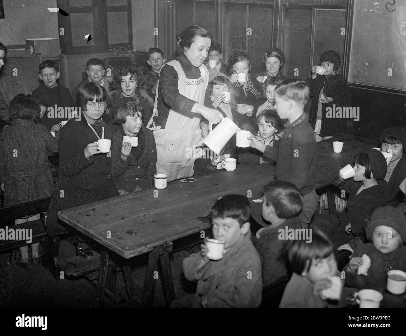 I bambini acquistano la propria colazione sulla strada per la scuola , a un farthing ciascuno ! . I bambini , freddi e ungheresi , possono acquistare la propria colazione per un farthing sulla loro strada per la scuola al centro di buona volontà dell' Esercito della salvezza ' in Cirencester Street , Paddington . Circa 250 bambini a settimana vengono serviti al centro , la maggior parte dei quali da case dove non c'è alcuna colazione . Ai bambini vengono dati molto cacao caldo , pane e marmellata e porridge . Se non riescono a pagare la farcosa, hanno comunque la colazione. Spettacoli fotografici, serve colazione farthing. Spettacoli fotografici, che serve colazioni da farthing a chil Foto Stock