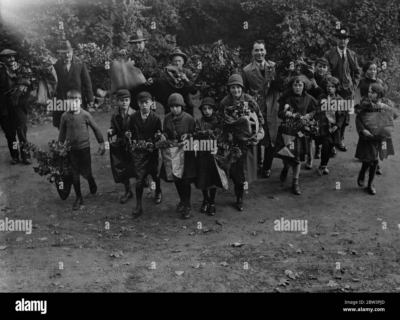Distribuzione di impianti a Battersea Park . Bambini che camminano con piante nel Parco di Battersea . 19 ottobre 1935 Foto Stock
