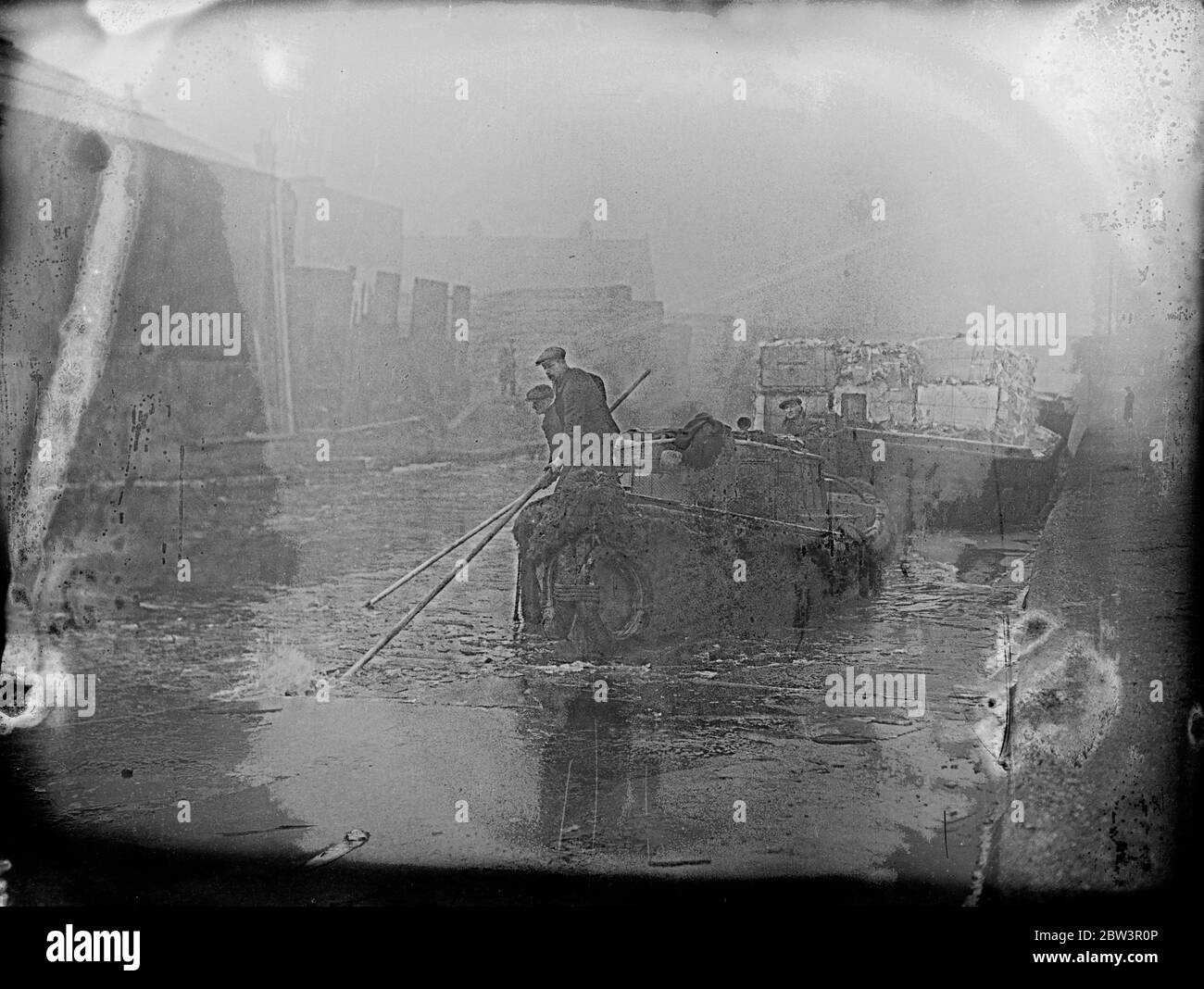 Gli uomini di chiatte hanno dovuto rompere il ghiaccio spesso prima di poter prendere la loro imbarcazione attraverso il canale di Surrey a Camberwell , dove è stato congelato dal tempo severo . Spettacoli fotografici , rompendo il ghiaccio del canale del Surrey da una chiatta a Camberwell . 12 febbraio 1936 Foto Stock