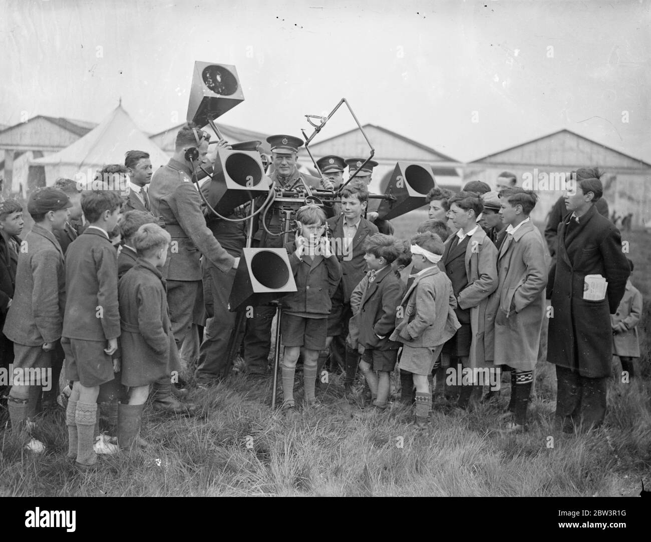 I bambini imparano a conoscere le difese aeree in occasione dell'Empire Air Day a Hendon . Grandi folle , tra cui molti bambini , hanno guardato l'esposizione Empire Air Day all'Hendon Aerodrome . L'11° Reggimento londinese (The Finsbury Frifles ) , che ora comprende le batterie degli aerei 171 e 170, ha collaborato con la Royal Air Force in mostra . Spettacoli fotografici , bambini che provano un posto di ascolto anti-aereo a Hendon . 23 maggio 1936 Foto Stock