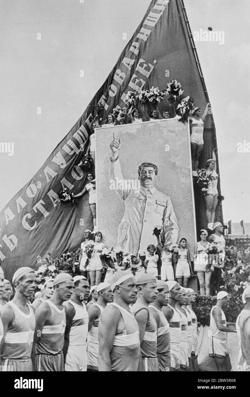 Banner vivente nella parata di Mosca di 75 , 000 atheletes . Le atlete di ragazza con fiori hanno incorniciato un immenso ritratto di Joseph Stalin , dittatore sovietico , quando una grande sfilata di 75 , 000 atleti e bambini passò sulla Piazza Rossa , Mosca , in occasione della Giornata della Costituzione Sovietica . La processione ha impiegato sei ore per attraversare la piazza e fu guardata da Stalin . Le celebrazioni sono state le più belle viste a Mosca dal Revoluton . Ciò era conforme al decreto di Stalin secondo cui la vita è diventata gioiosa. Foto spettacoli , il banner vivente nella processione degli atleti . L'iscrizione è Stalin Foto Stock