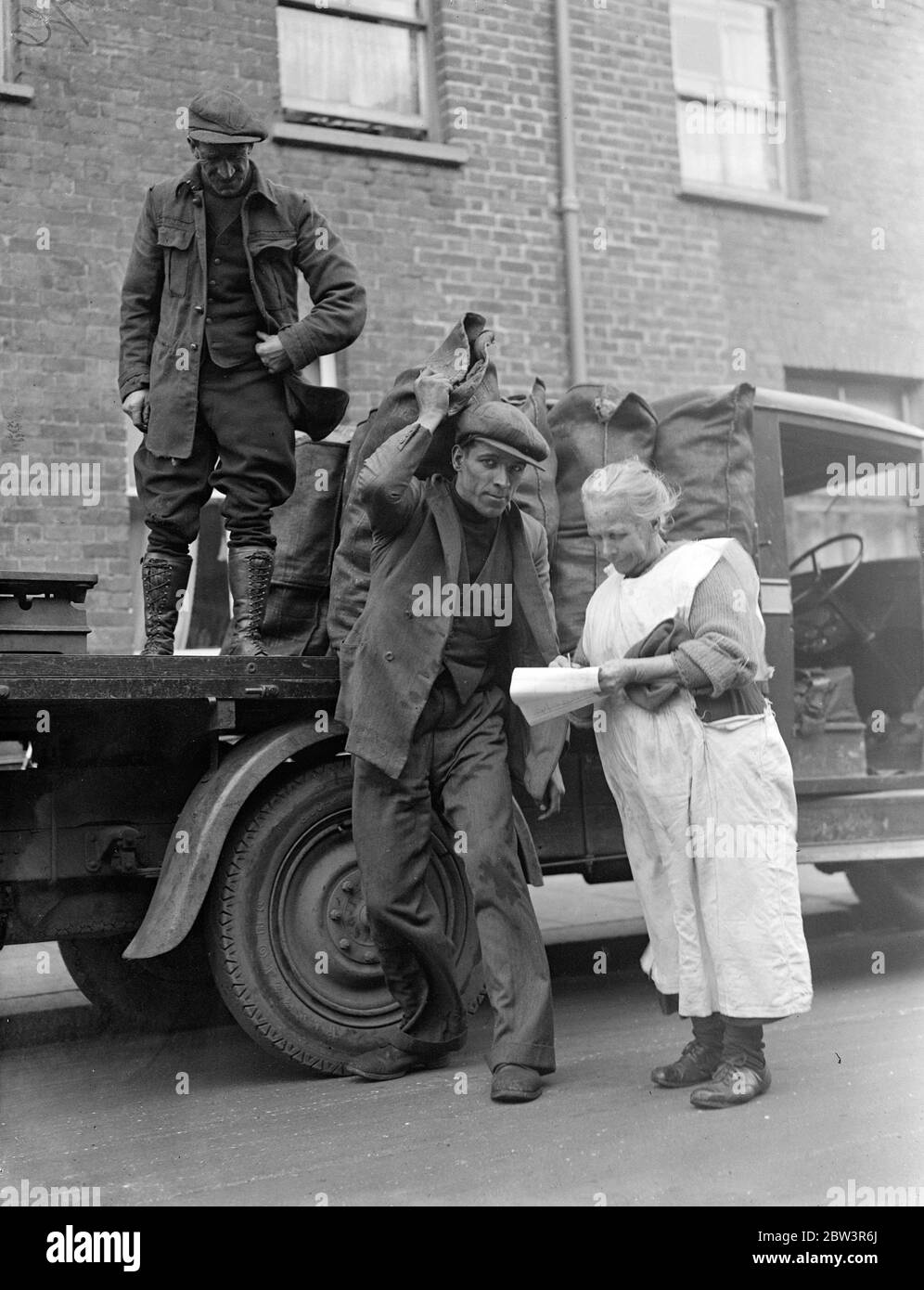 Distribuzione annuale di carbone di natale data da King a Windsor . La distribuzione annuale di carbone di Natale data dal Re ai poveri di Windsor e del distretto , si è svolta a Windsor . Foto mostra la signora Bird di Arthur Road , Windsor che riceve il suo carbone . 16 dicembre 1935 Foto Stock