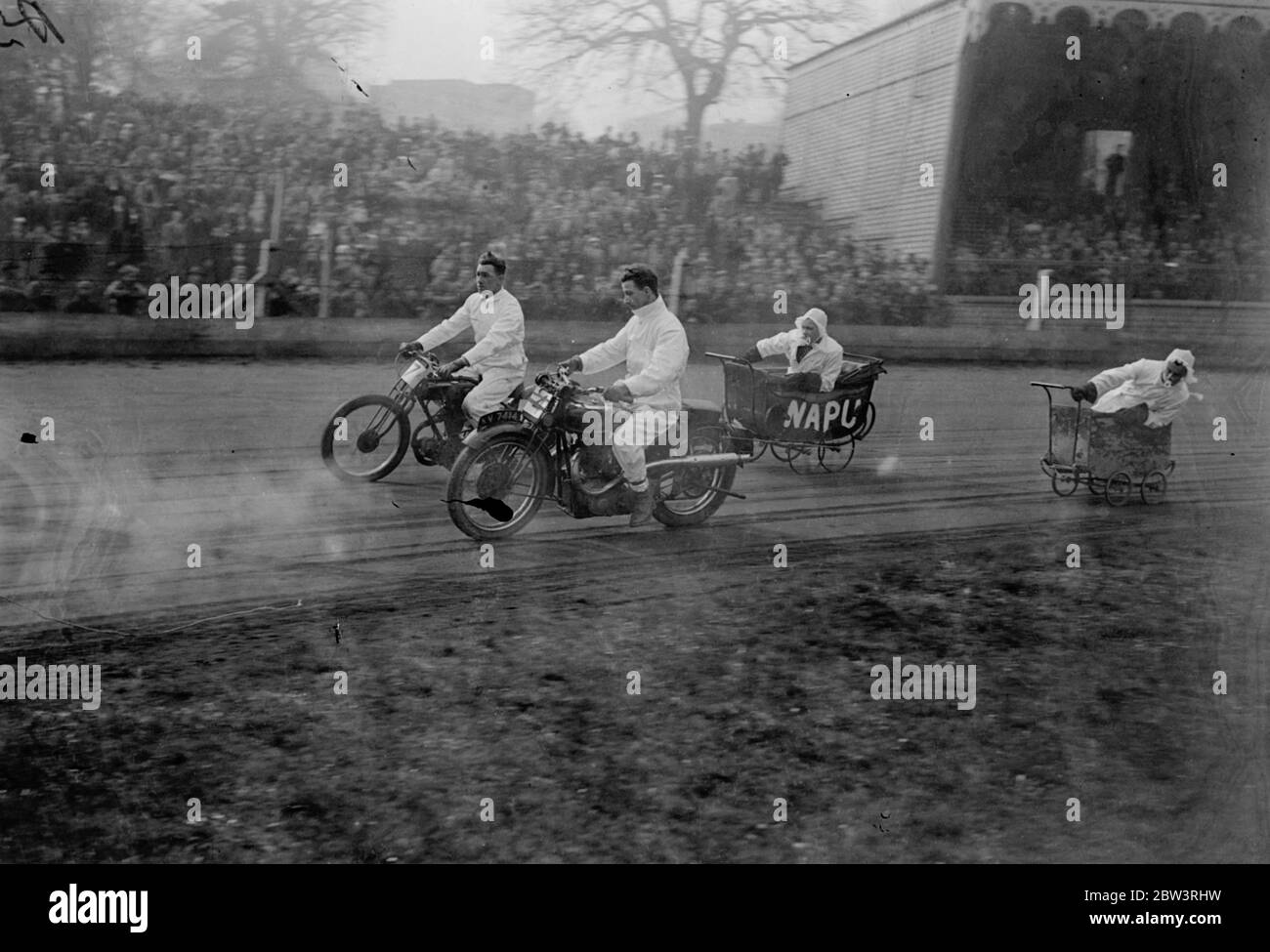 Il parambulatore urta il ciclo del motore al Crystal Palace . Un rodeo in bici per le festività è stato tenuto sul campo da calcio del Crystal Palace . Foto mostra , il ciclo del perambulatore nella corsa del perambulatore . 13 aprile 1936 Foto Stock