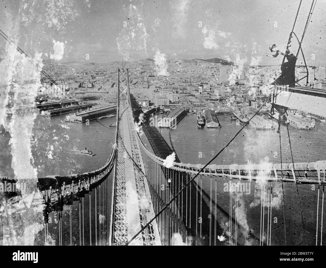 Gettando la sua ombra sulle acque . Il Ponte Gigante di San Francisco, a pochi mesi di completamento, ha gettato la sua sottile ombra di otto e un quarto di miglia sulle acque della Baia di San Francisco , il gigantesco ma grazioso San Francisco - l'Oakland Bay Bridge si eleva sulla città verso il completamento . A novembre, quando il ponte sarà aperto , gli automobilisti avranno una nuova strada per San Francisco sulla più grande campata del mondo . Sei corsie di traffico saranno accomodate sul ponte superiore del ponte, mentre in basso un treno interurbano e tre treni commerciali correranno. Quando è stato completati Foto Stock