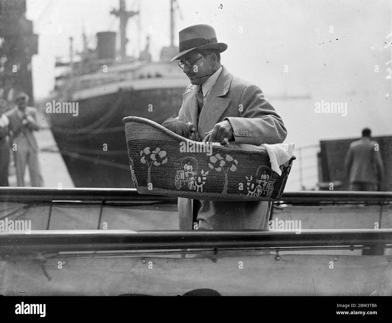 Irving Asher porta il bambino a terra in culla dalla Normandia . Signor . Irving Asher , marito di Laura la Plante , l'attrice del film , portò il loro bambino a terra in una culla quando arrivò a Southampton sul liner Normandie dagli Stati Uniti . Il bambino è nato a Londra . Spettacoli fotografici : MR. Irveg Asher che porta il suo bambino a terra in una culla dalla Normandia all'arrivo a Southampton . 10 ago 1936 Foto Stock