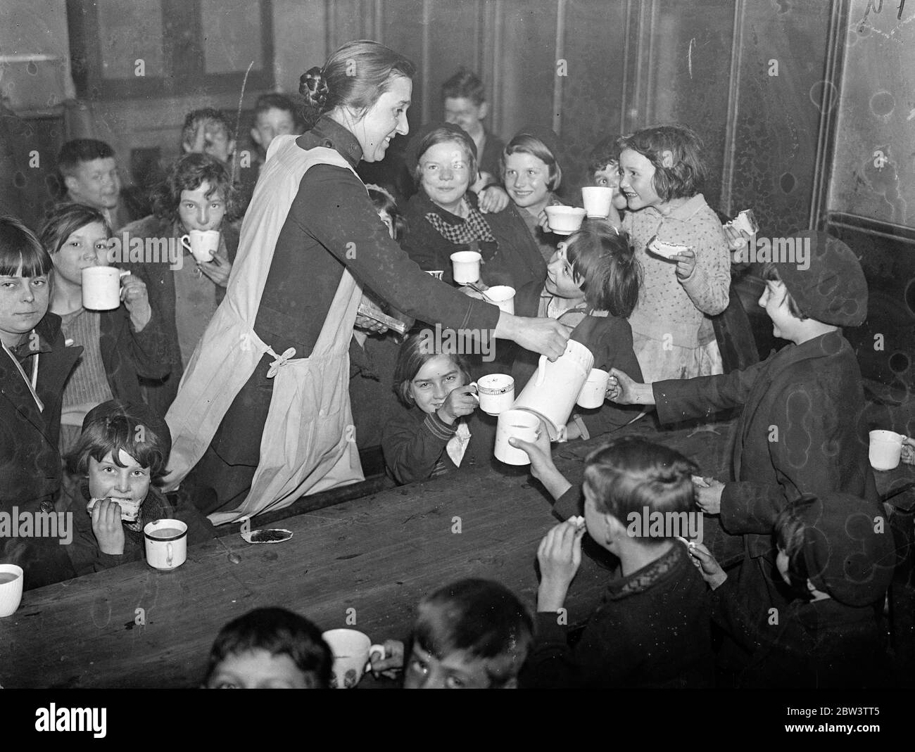 I bambini acquistano la propria colazione sulla strada per la scuola , a un farthing ciascuno ! . I bambini , freddi e ungheresi , possono acquistare la propria colazione per un farthing sulla loro strada per la scuola al centro di buona volontà dell' Esercito della salvezza ' in Cirencester Street , Paddington . Circa 250 bambini a settimana vengono serviti al centro , la maggior parte dei quali da case dove non c'è alcuna colazione . Ai bambini vengono dati molto cacao caldo , pane e marmellata e porridge . Se non riescono a pagare la farcosa, hanno comunque la colazione. Spettacoli fotografici, serve colazione farthing. Spettacoli fotografici, che serve colazioni da farthing a chil Foto Stock