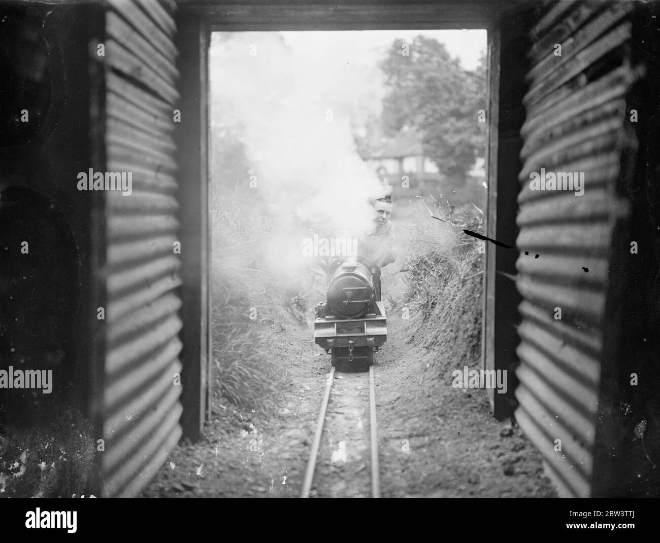 Sistema ferroviario di miniature realizzato in un giardino di Kenton . Hobby porta Fondi per Ospedali locali esprime speciali , e i freighters che girovagano attraverso talee , incroci , tunnel , su ponti e tirando in tempo termini - tutti i normali lavori di una grande ferrovia - sono realizzati nello spazio di un giardino An Kenton , Middlesex . Signor . J . R . Jeffress di Kenton Grange ha costruito una delle più ambiziose ferrovie in miniatura nei terreni della sua casa . Disegnò la sua propria disposizione e costruì i propri locomotori , nominando uno Giorgio il quinto . Costruito a 0 indicatore il sistema ha Foto Stock