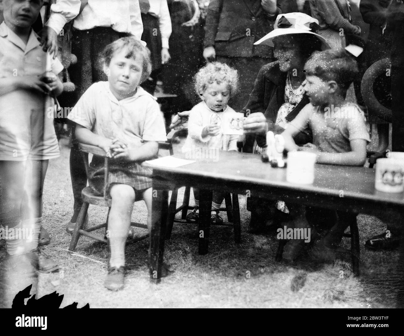 Il primo rifugio vivaio aperto nel Parco di Battersea . Sir Bruce Porter . Mostre fotografiche , Lady Crosfield , Presidente della Società Nazionale dei vivai del giorno , accoccolato con alcuni bambini alla cerimonia . 1 agosto 1935 Foto Stock