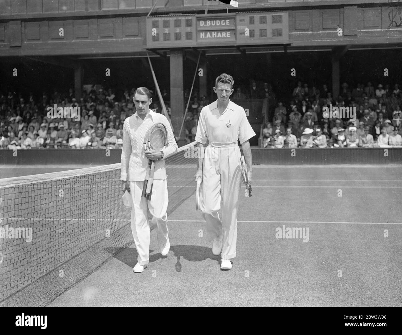 Campionato di tennis di Wimbledon aperto . Il primo contro Hare vince il Bridge . Il primo round dei singoli uomini ha aperto il Wimbledon Tennis Championship . Donald Budge , l'americano ha vinto il primo set contro H . R . Lepre ( GB ) 6 - 1 sul n. 1 Corte . Spettacoli fotografici : Donald Buedge (a destra) e H . R . Lepre che cammina su . 22 Jun 1936 Foto Stock