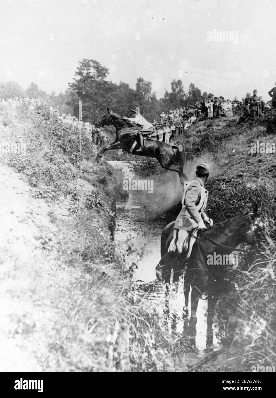 Prendendolo nel suo passo . Nurmi , guidato da Capt Stubbendorff di Germania , che si trova tra le alte rive di a , uno degli ostacoli più difficili nelle gare di equitazione dei Giochi Olimpici di Toberitz . Questo salto è stato un incubo per i concorrenti l'uomo in primo piano, avendo fallito tre volte . 16 agosto 1936 Foto Stock