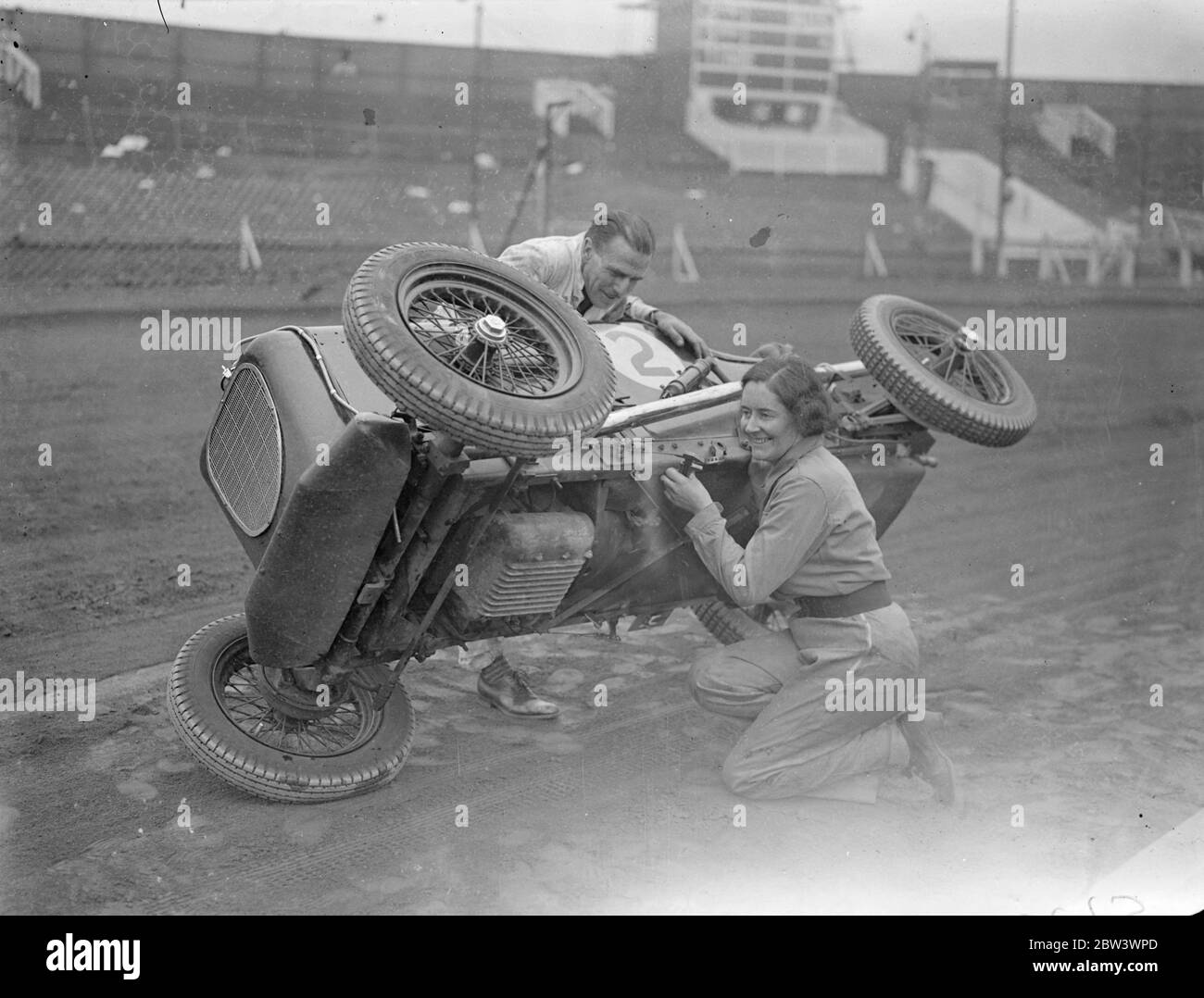 La donna driver prende su corsa di automobile di midget. Fay Taylor , noto pilota di corse e un tempo titolare del campionato femminile di speedway , sta ora prendendo parte alle corse automobilistiche di Midget . Lei gareggerà in tutto il paese Photo Shows , Fay Taylor facendo un adeguamento al suo Sulman Special , Midget auto a West Ham Stadium , assisited da Tommy Sulman , il progettista di auto Midget e driver . 19 agosto 1936 Foto Stock