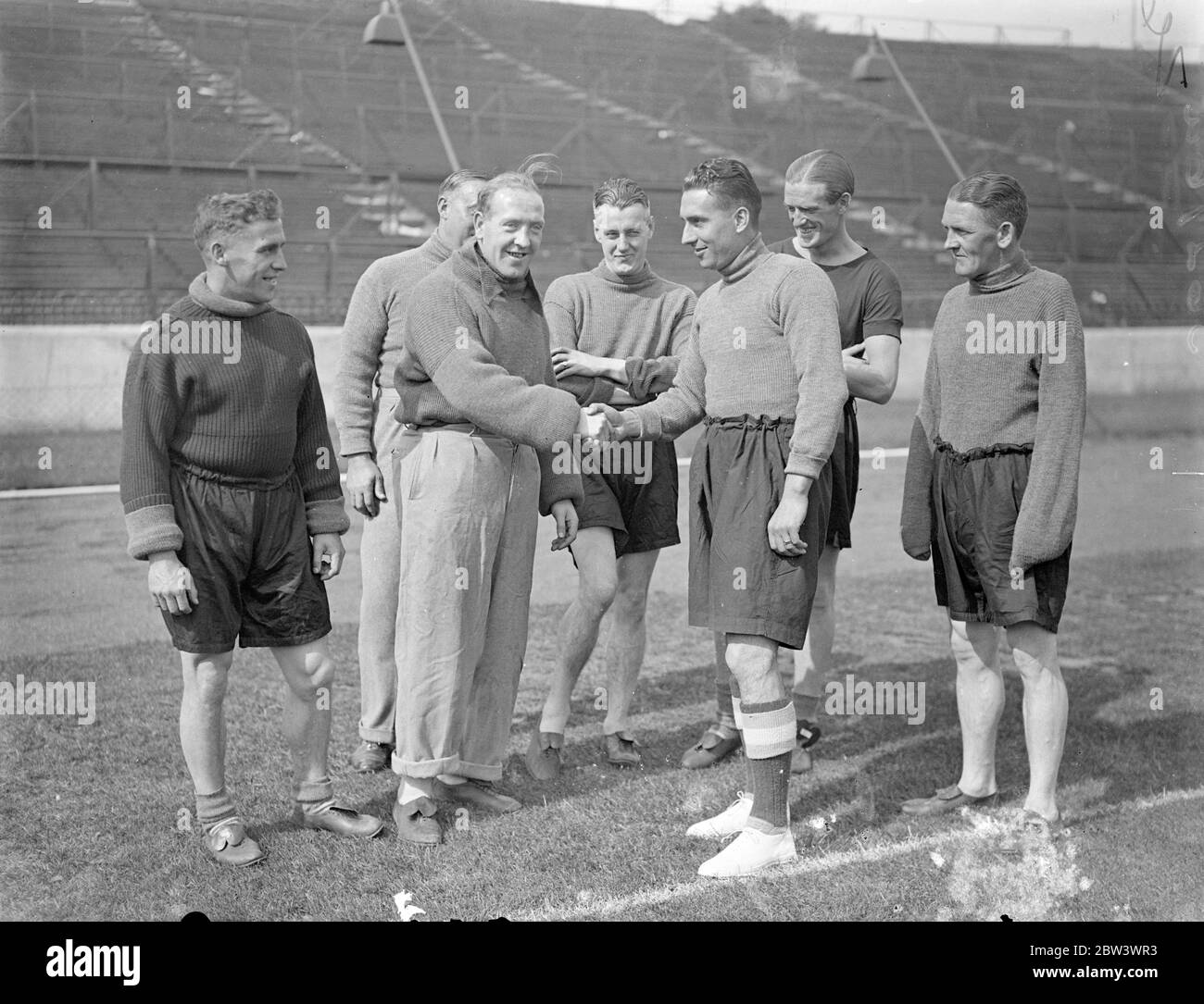 Sam Weaver si unisce al nuovo team dopo il trasferimento a Chelsea da Newcastle . Pioneer of the long' throw in' può lanciare la palla da touchline a goalpost , Sam Weaver , il Newcastle United e l'Inghilterra ha lasciato il mezzo di ritorno che è stato trasferito a Chelsea , si è Unito alla sua nuova squadra al Stamford Bridge , Londra , Ground . Weaver capitanò Newcastle la scorsa stagione , facendo 31 apparizioni di campionato . Nel 1932 fu chiuso contro la Scozia e nel 1933 contro la Scozia e l'Irlanda. Foto mostra , Sam Weaver ( a destra ) scuotendo le mani con Tommy Law , il Chelsea indietro , come è stato ricevuto dai membri della sua nuova squadra A. Foto Stock