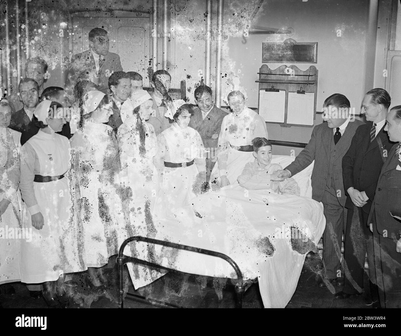 George Allison svela il letto all'Arsenal's Hospital . Compagnia dei membri della squadra, George Allison , direttore della squadra di calcio dell'Arsenal , ha presentato il letto Paramount dotato della società filantropica Paramount al Royal Northern Hospital di Holloway , Londra . E' al Royal Northern Hospital che la maggior parte dei giocatori arsenali feriti vanno per trattamento . La società che dispone del letto è distribuito vicino al Â£20,000 durante gli ultimi sette anni gli ospedali londinesi . La foto mostra il signor George Allison che stringe le mani con Reg Parson , occupante del letto Paramount , dopo la cerimonia sorvegliata Foto Stock