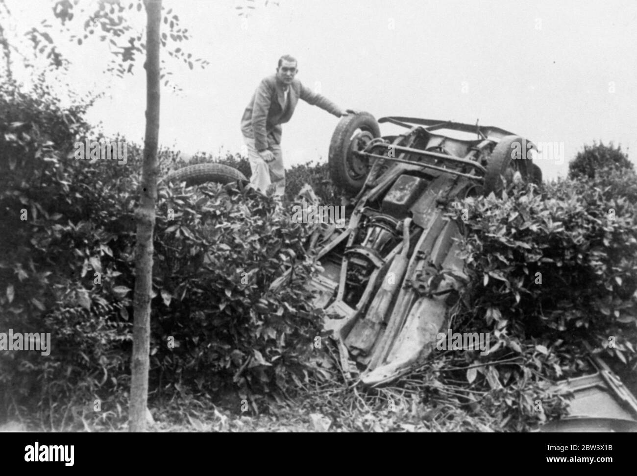 Cosa deve fare a un'automobile. Foto spettacoli : la batteria sotto la struttura di un'automobile - che è stata colpita cantieri in aria dall'esplosione di una conchiglia durante un bombardamento da parte dei ribelli spagnoli di San Sebastien e atterrato capovolto su una siepe . Uno degli pneumatici è visto a una certa distanza . Altri frammenti sono stati sparsi su un'ampia area. 26 agosto 1936 titolo originale da negativo Foto Stock