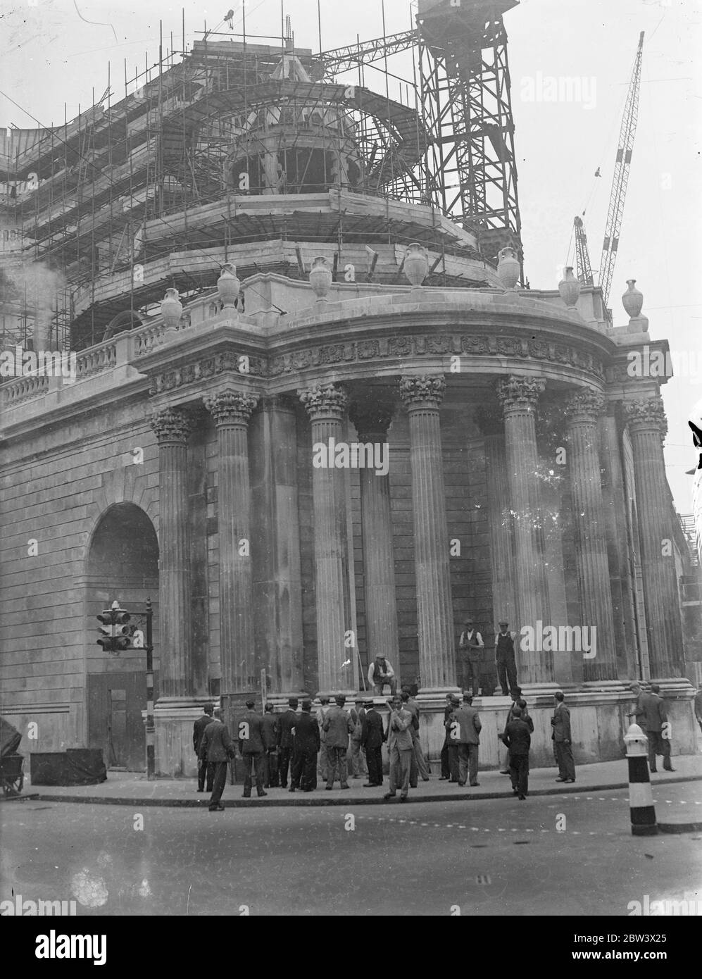 Sorgendo dal suo labirinto di ponteggi , la nuova ala della Banca d'Inghilterra si aggiunge alla bellezza architettonica della città , le sue graziose colonne e la facciata bianca sumbolica di una nuova epoca . I lavori stanno rapidamente progredendo sull'ala , ma devono passare ancora molti anni prima che l'edificio sia completato e pronto per l'uso . Foto mostra , la nuova ala della Banca d'Inghilterra che si erge dalla cornice in acciaio del ponteggio . 2 settembre 1936 . Didascalia originale da negativo Foto Stock