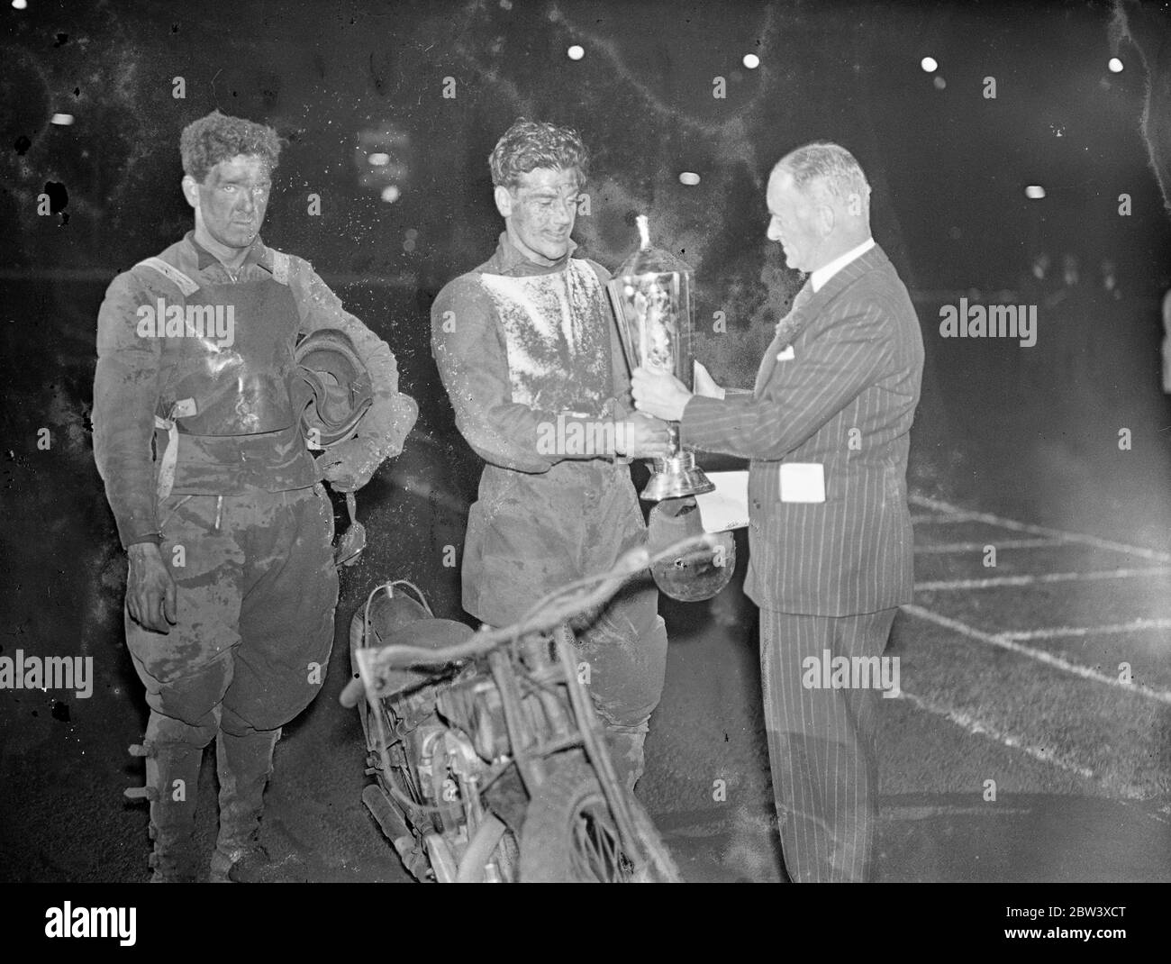 Lionel van Praag vince il primo campionato mondiale di speedway . Lionel van Praag , il capitano internazionale australiano e Wembley divenne il primo campione mondiale di speedway allo stadio Wembley di Londra . Alla fine del 20 si scalda Van Praag e Eric Langton di Belle Vue, Manchester, legato con 26 punti. Van Praag sconfisse Langton nel decisore . Bluey Wilkinson di West Ham era terzo. Foto : Sir Malcolm Campbell presenta il trofeo mondiale a Lionel van Praag . Sulla sinistra si trova Eric Langton , secondo classificato. 11 settembre 1936 Foto Stock